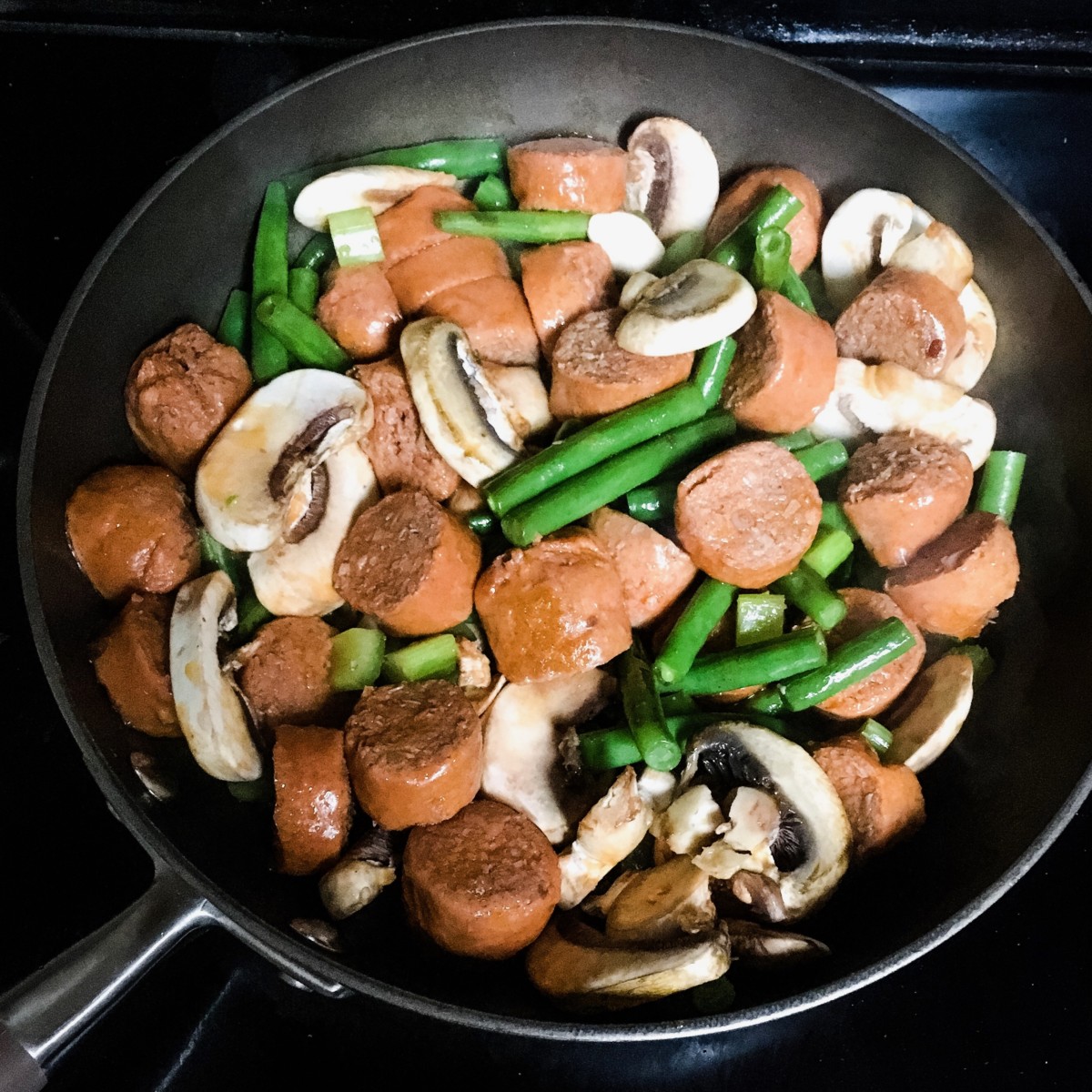 vegetables and veggie sausage cooking in a skillet