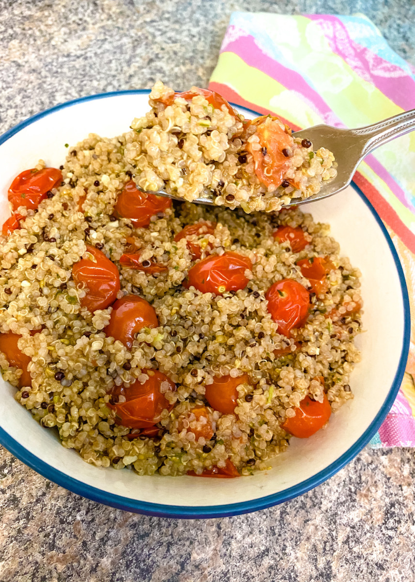 fork dipping into quinoa and grape tomatoes