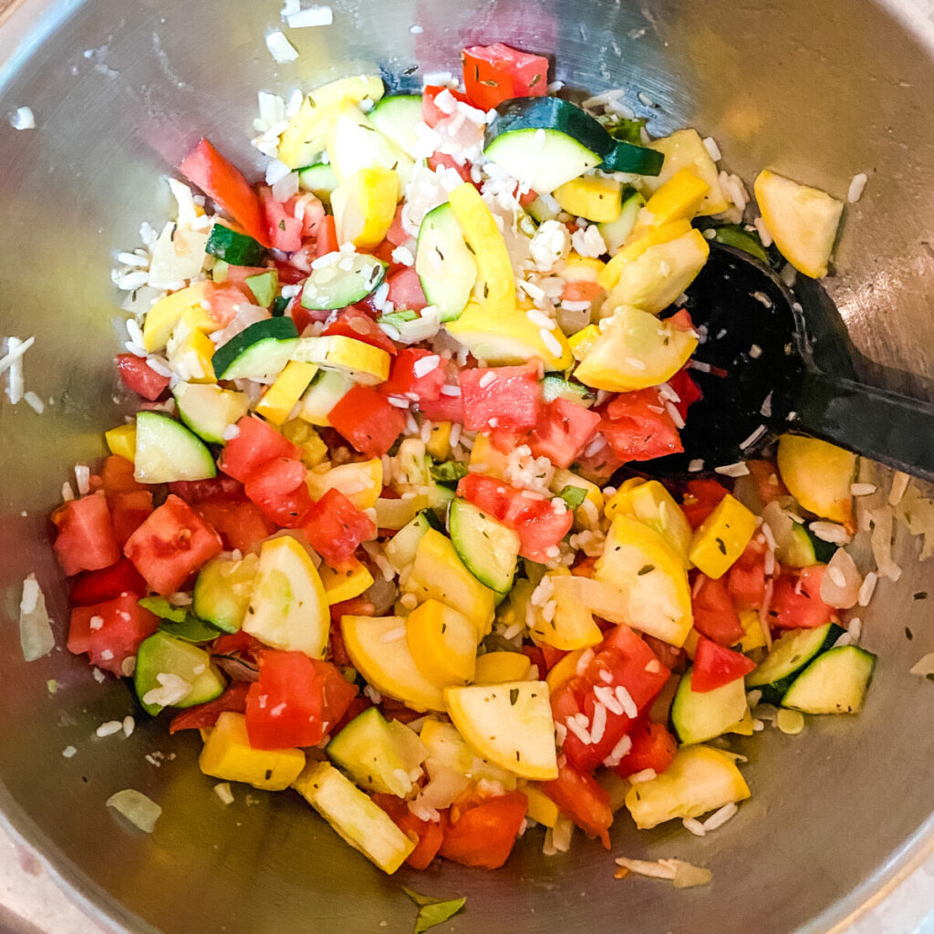 summer vegetable casserole ingredients being stirred