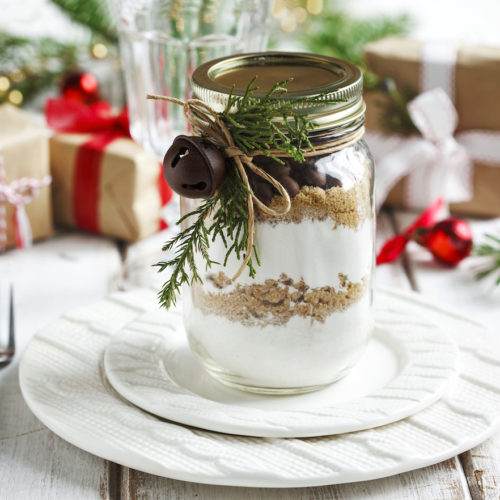 a jar of cookie baking mix wrapped as a gift on a holiday table